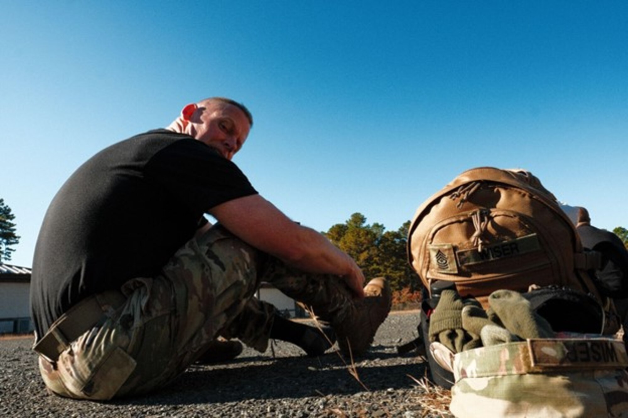 A man prepares his boots for a march