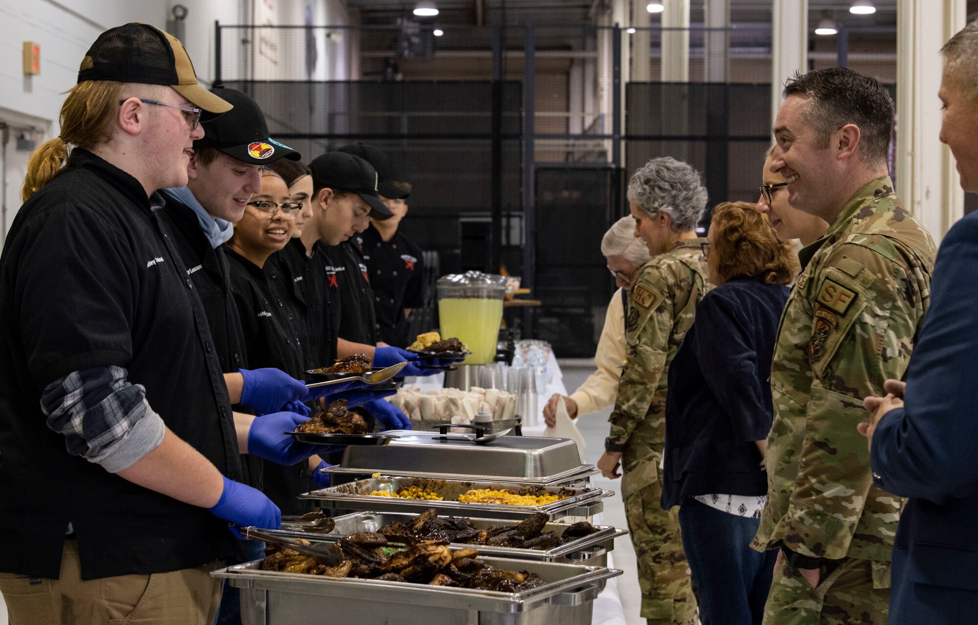 POLYTECH High School culinary art students serve a buffet-style lunch during the 2023 Honorary Commanders Induction Ceremony at Dover Air Force Base, Delaware, Oct. 20, 2022. Students enrolled in the program are introduced to concepts and methods of the restaurant industry. (U.S. Air Force photo by Roland Balik)