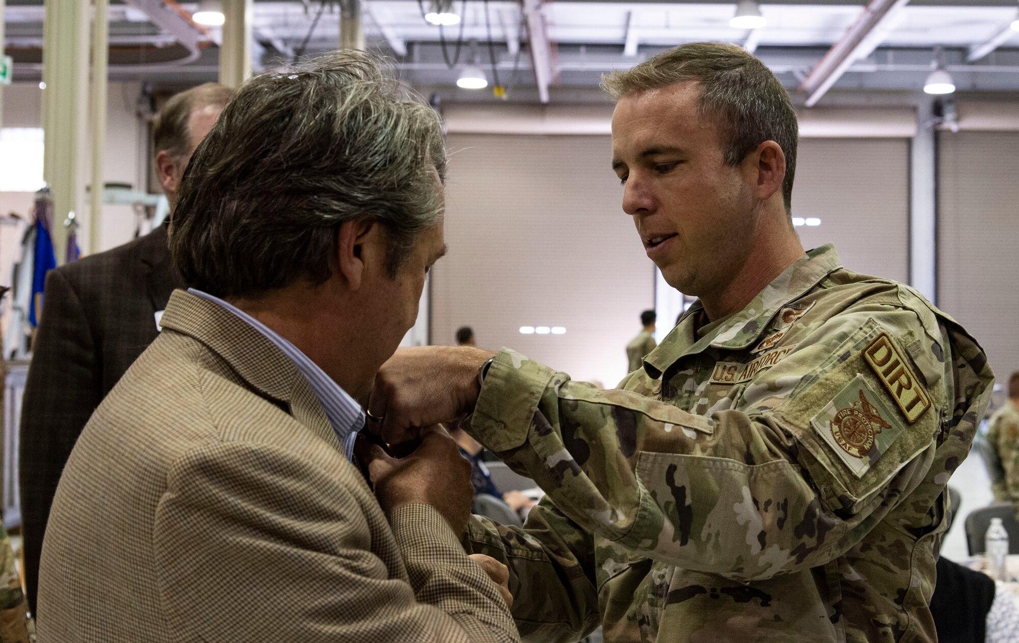 Lt. Col. Joshua Yerk, right, 436th Civil Engineer Squadron commander, places a squadron commander badge on Shane Breakie, Chesapeake Utilities vice president, during the 2023 Honorary Commanders Induction Ceremony at Dover Air Force Base, Delaware, Oct. 20, 2022. Breakie, along with forty-one other local civic and business leaders were inducted into the HCC program. He will serve as the HCC for the 436th CES. (U.S. Air Force photo by Roland Balik)