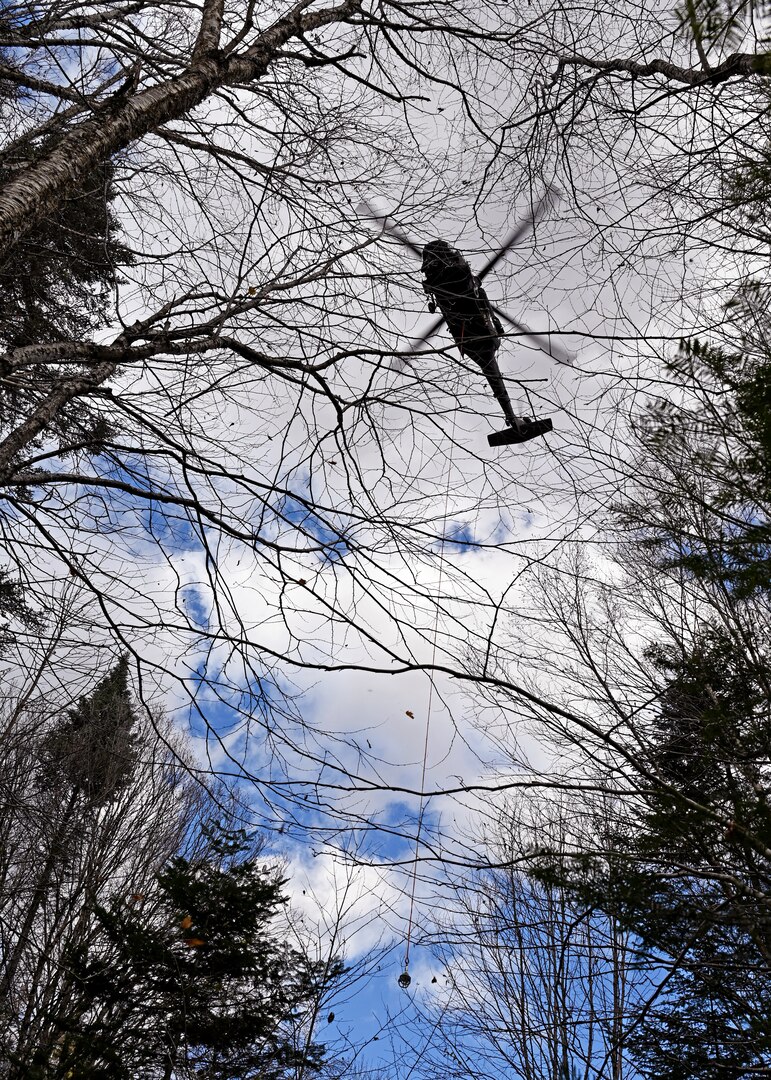 A New Hampshire Army National Guard Black Hawk helicopter lowers a 130-foot “long line” toward a ground crew to extract a rusted metal culvert from Nash Stream on Oct. 19, 2022