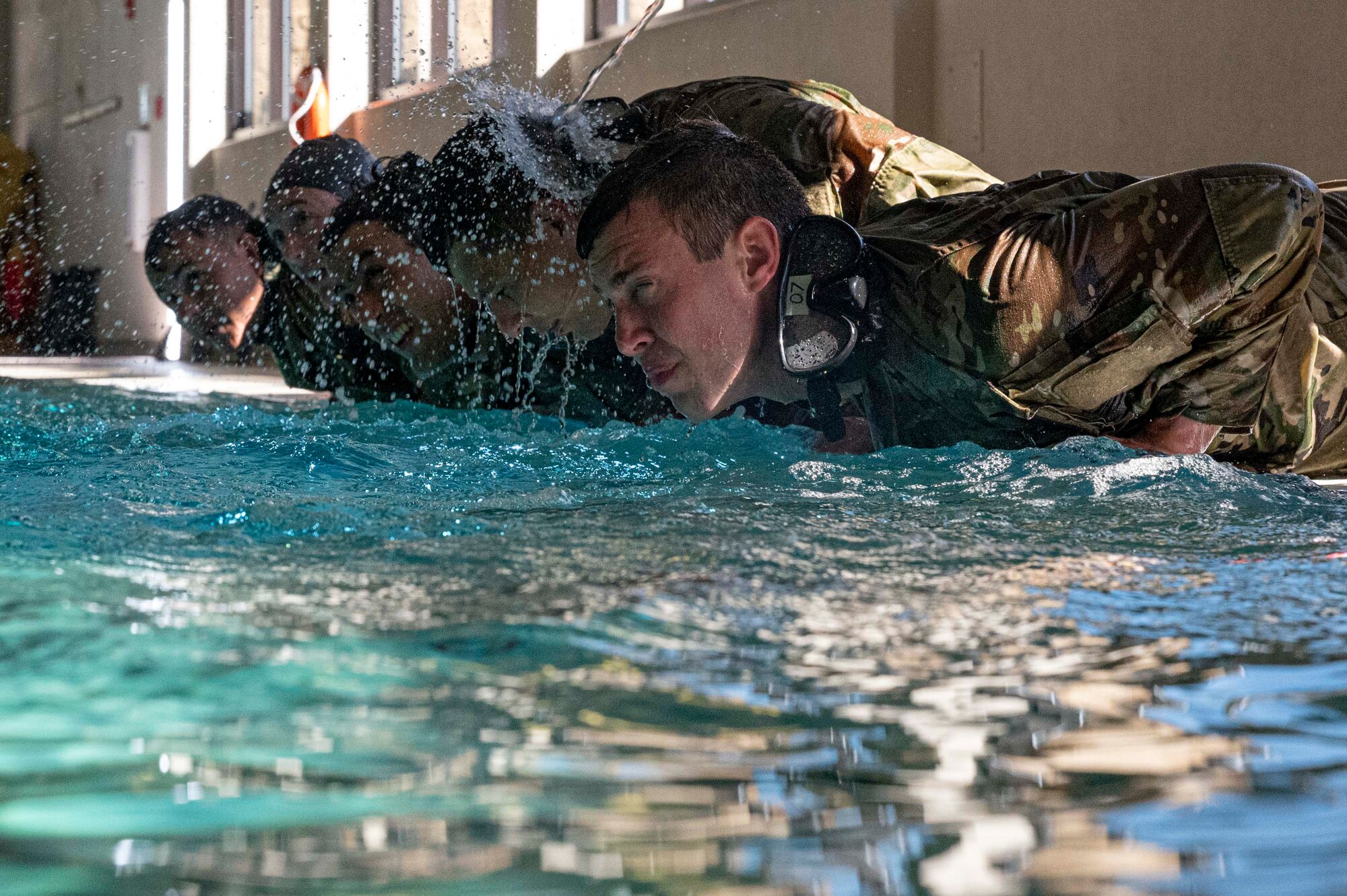 Pictured above are people lying down on a pool deck facing the water.