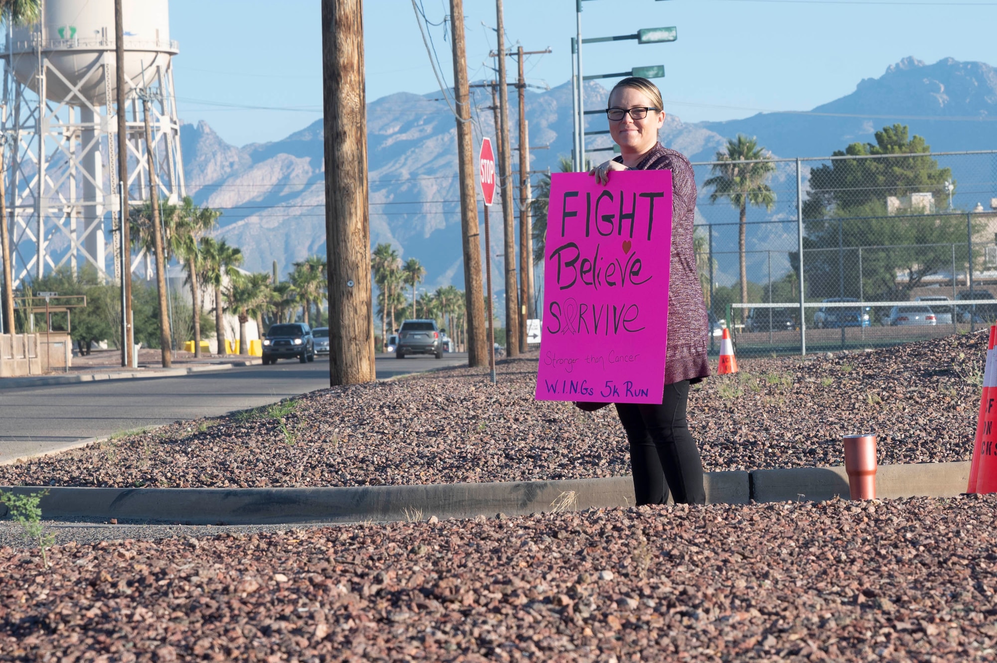 Pictured above is a woman holding a morale sign by a road.