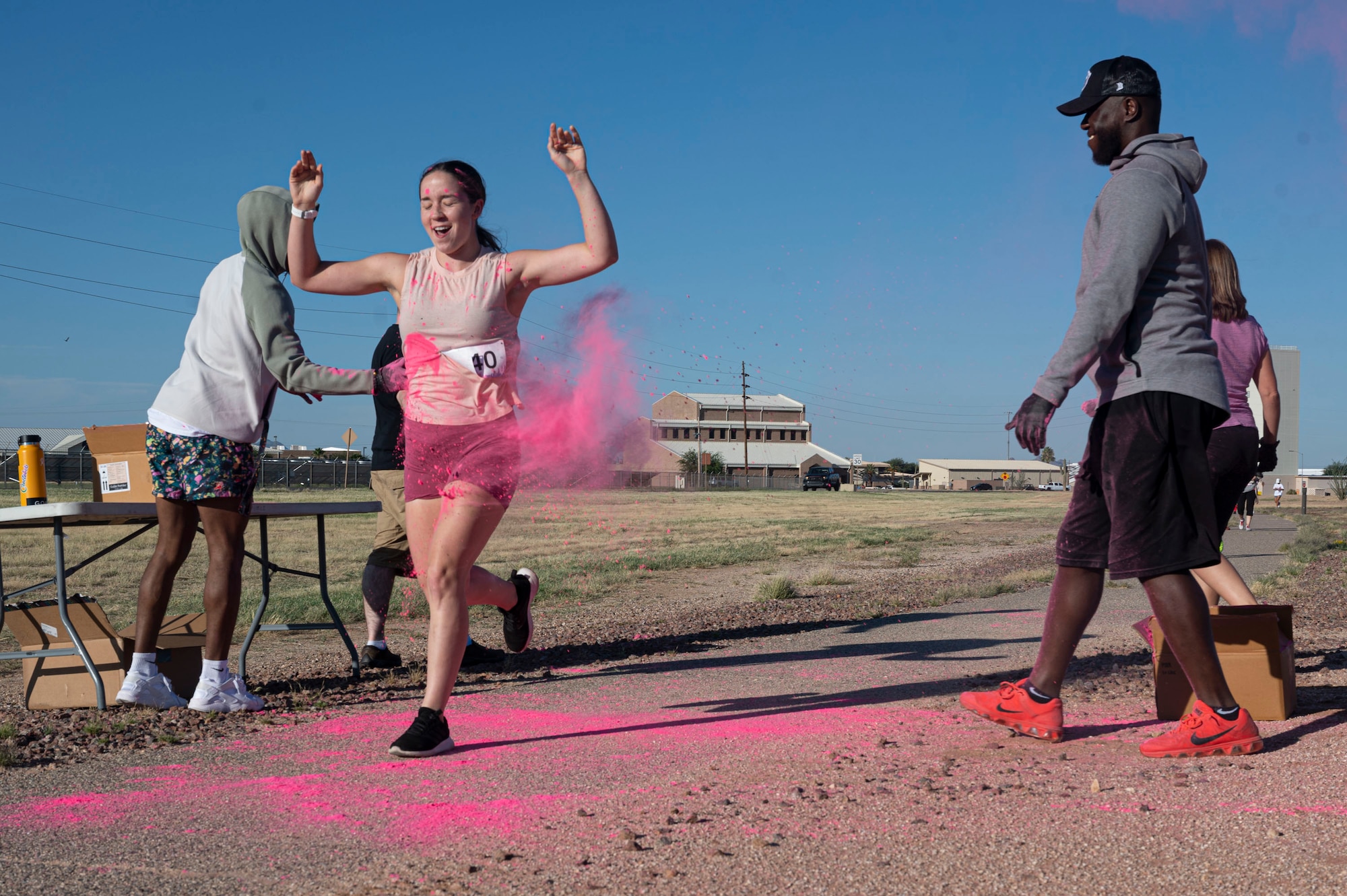 Pictured above is a woman running trough a cloud of pink smoke.