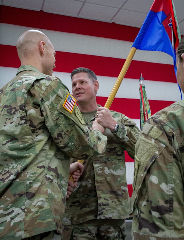 Maj. Gen. Marty Klein passes the 75th Innovation Command's Headquarters and Headquarters Detachment colors to outgoing commander Maj. Christopher Allen during a change of command ceremony at the 75th Innovation Headquarters, Oct. 23, 2022. Maj. Brandon Trama assumed command of the HHD. (U.S. Army photo by Maj. Charles An, 75th Innovation Command)