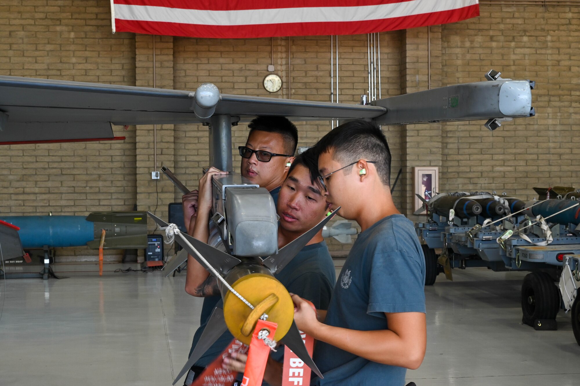 Singaporean air force ME1 Boon Soon Wong (front), ME1 Jia Jun Jeff Hong (middle), and ME2 Guo Xiong Ngim (back), load an AIM-9LM Sidewinder missile during a load competition, Oct. 7, 2022, at Luke Air Force Base, Arizona.