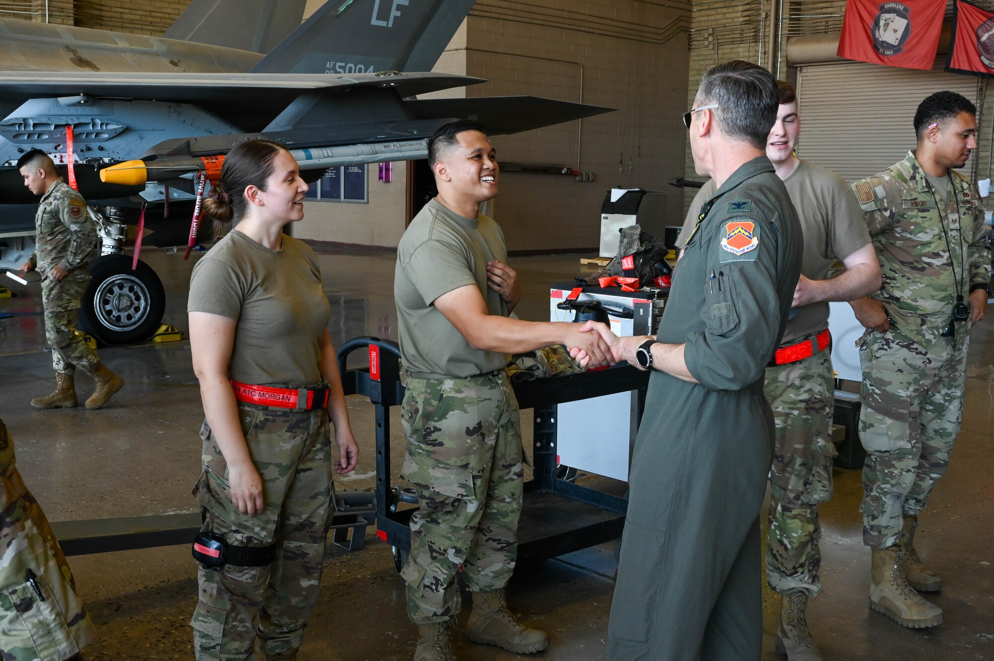 U.S. Air Force Col. Keagan McLeese, 56th Fighter Wing vice commander, congratulates a load crew from the 63rd Aircraft Maintenance Unit after a weapons load competition, Oct. 7, 2022, at Luke Air Force Base, Arizona.