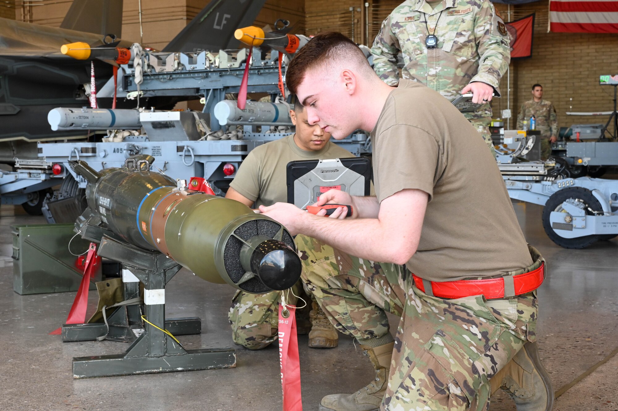 U.S. Air Force Senior Airman Wyatt Sparks (front) and Staff Sgt. Patrick Icari (back), 63rd Aircraft Maintenance Unit maintainers, prepare a GBU-12 Paveway II munition during a weapons load competition, Oct. 7, 2022, at Luke Air Force Base, Arizona.