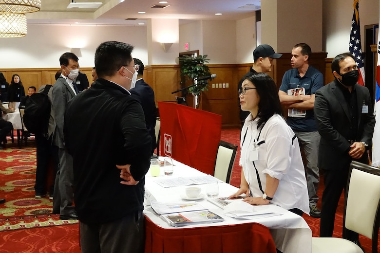 Chinkyong Kim (center), safety and occupational health specialist, Far East District, U.S. Army Corps of Engineers speaks with a participant of Industry Day, which was held at the Riverbend Golf Course Ballroom, U.S. Army Garrison Humphreys, Oct. 6. Kim provided a safety overview of the USACE’s safety and health requirements. (U.S. Army photo by Yo Kyong-il)