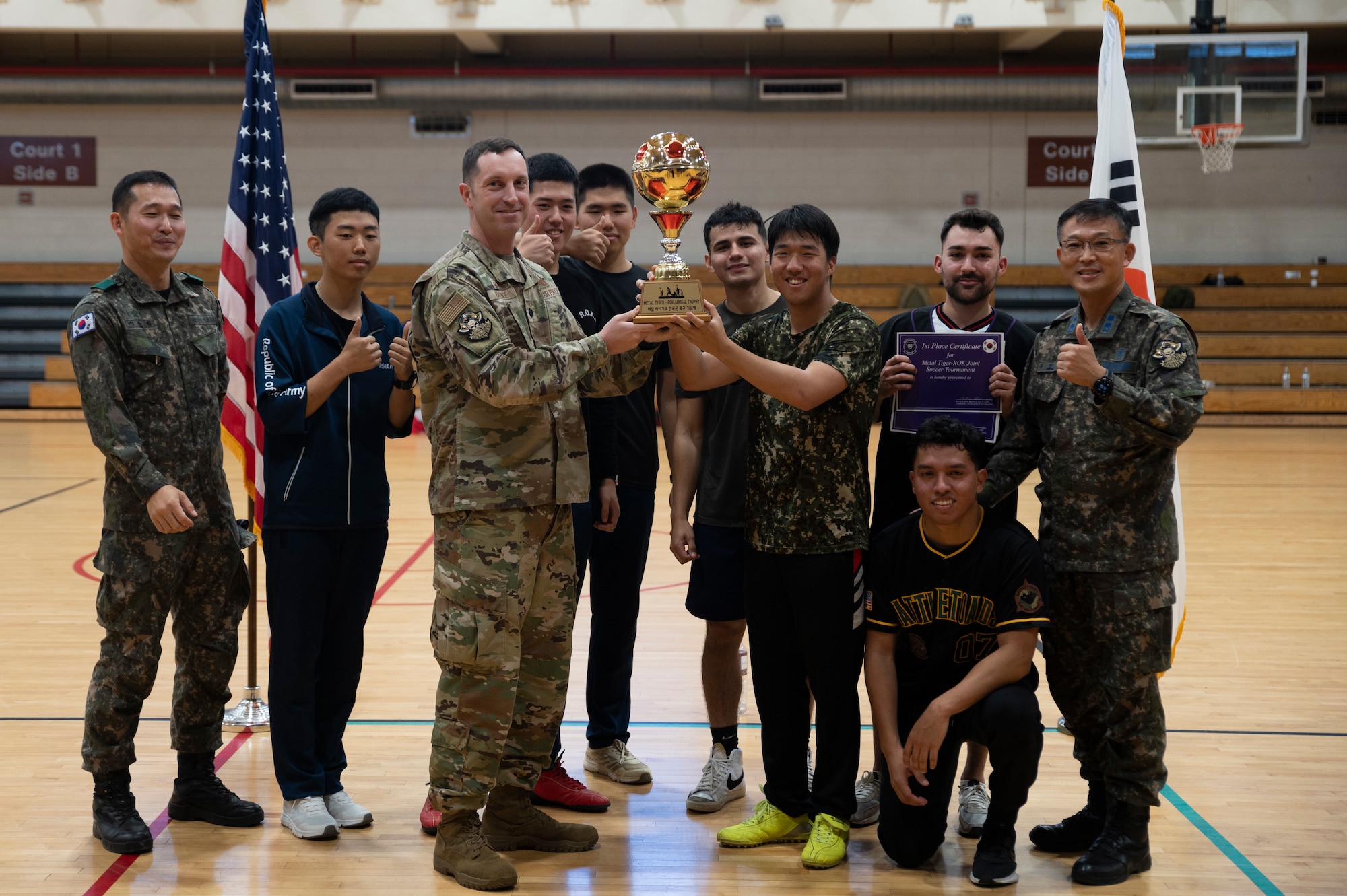 Republic of Korea and U.S. Service members receive the winning trophy from Lt. Col. Nicholas Brence, 51st Security Forces Squadron commander, after a bilateral soccer tournament at Osan Air Base, ROK, Oct. 21, 2022.