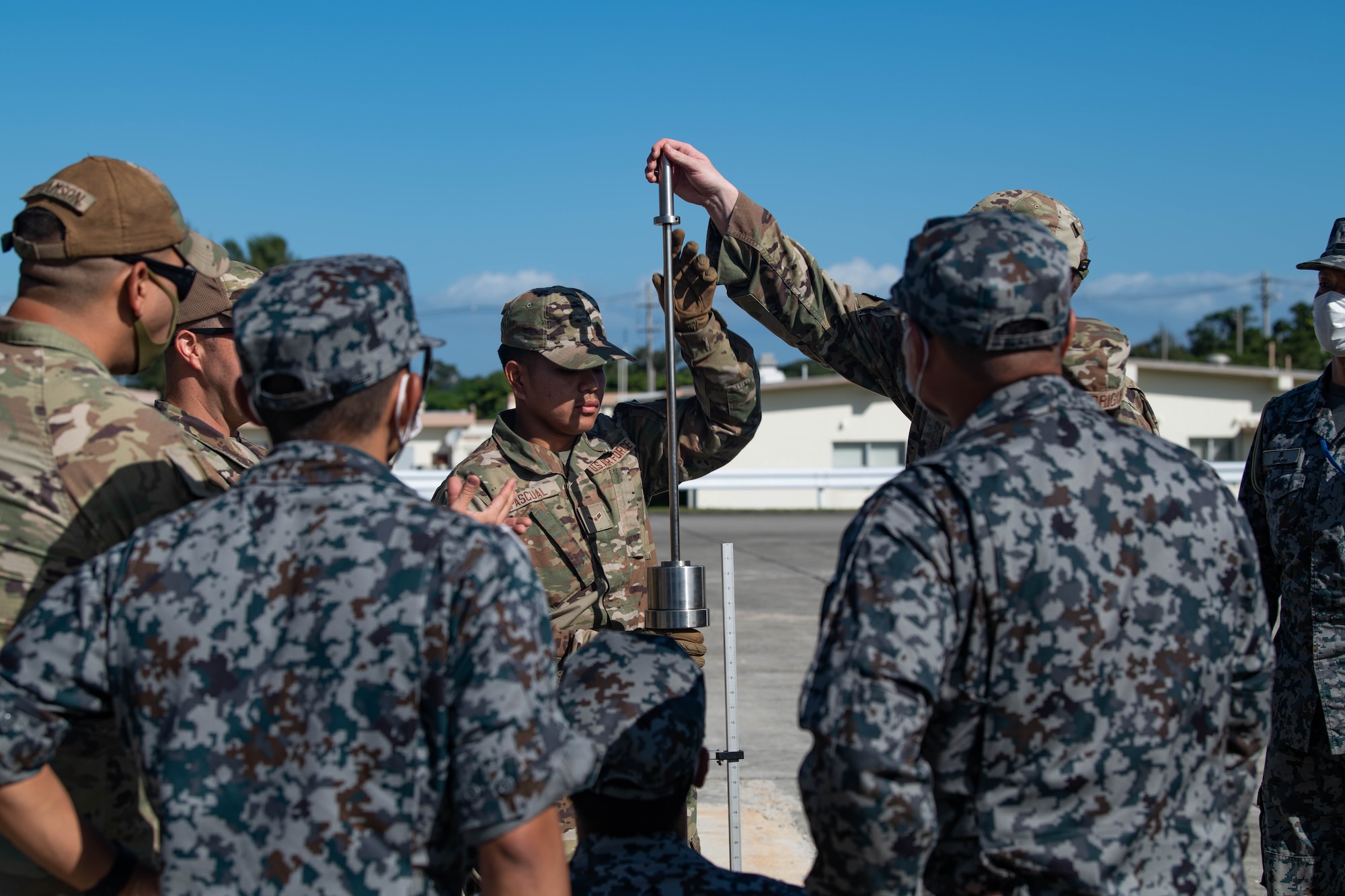 Airmen and Japan Air Self-Defense Force members measure ground compaction.