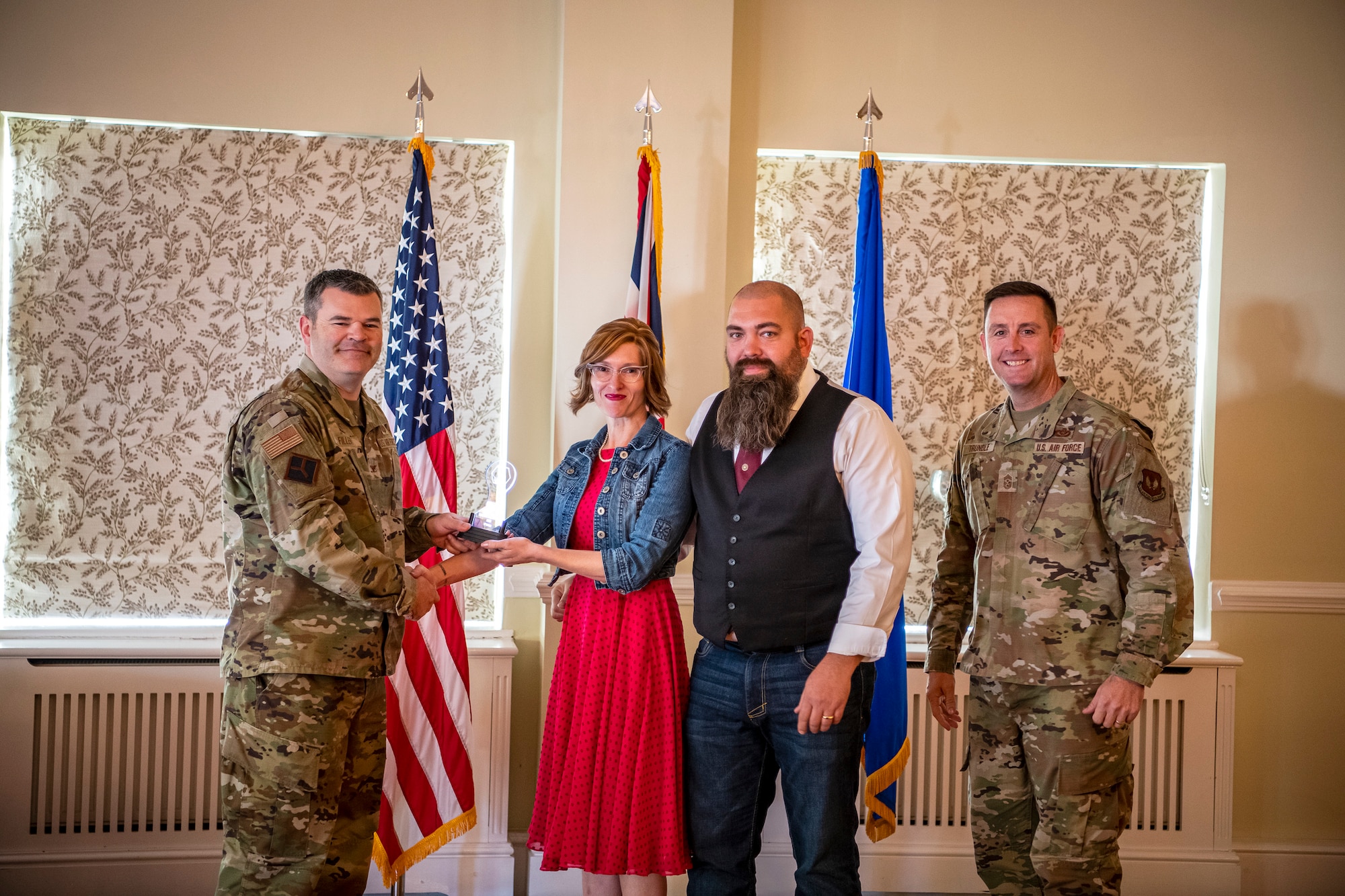 Corrine Cain, 423d Force Support Squadron school liaison specialist, and Jason Cain, center, accept an award from U.S. Air Force Col. Brian Filler, left, 501st Combat Support Wing commander and Chief Master Sgt. Joshua Trundle, 501st CSW command chief, during the Pathfinder Innovation Conference at RAF Alconbury, England, Oct. 21, 2022. The conference gave participants an opportunity to pitch their innovations, which were evaluated by a panel of judges and ranked based on their feasibility and overall benefit to the 501st Combat Support Wing mission. (U.S Air Force photo by Staff Sgt. Eugene Oliver)