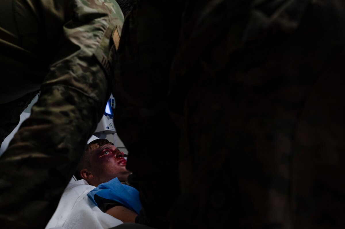 U.S. Air Force Staff Sgt. John Thacker, 386th Expeditionary Medical Squadron independent medical technician, simulates treating Airman 1st Class Serena Rubin, 386th Expeditionary Logistics Readiness Squadron fuels distribution operator (bottom), during a major accident response exercise at Ali Al Salem Air Base, Kuwait, October 20, 2022. Thacker was in charge of maintaining the patient's airway during the initial treatment response and simulated intubating the airway in response to the sustained injuries to maintain adequate care of the patient. (U.S. Air Force photo by Staff Sgt. Dalton Williams)