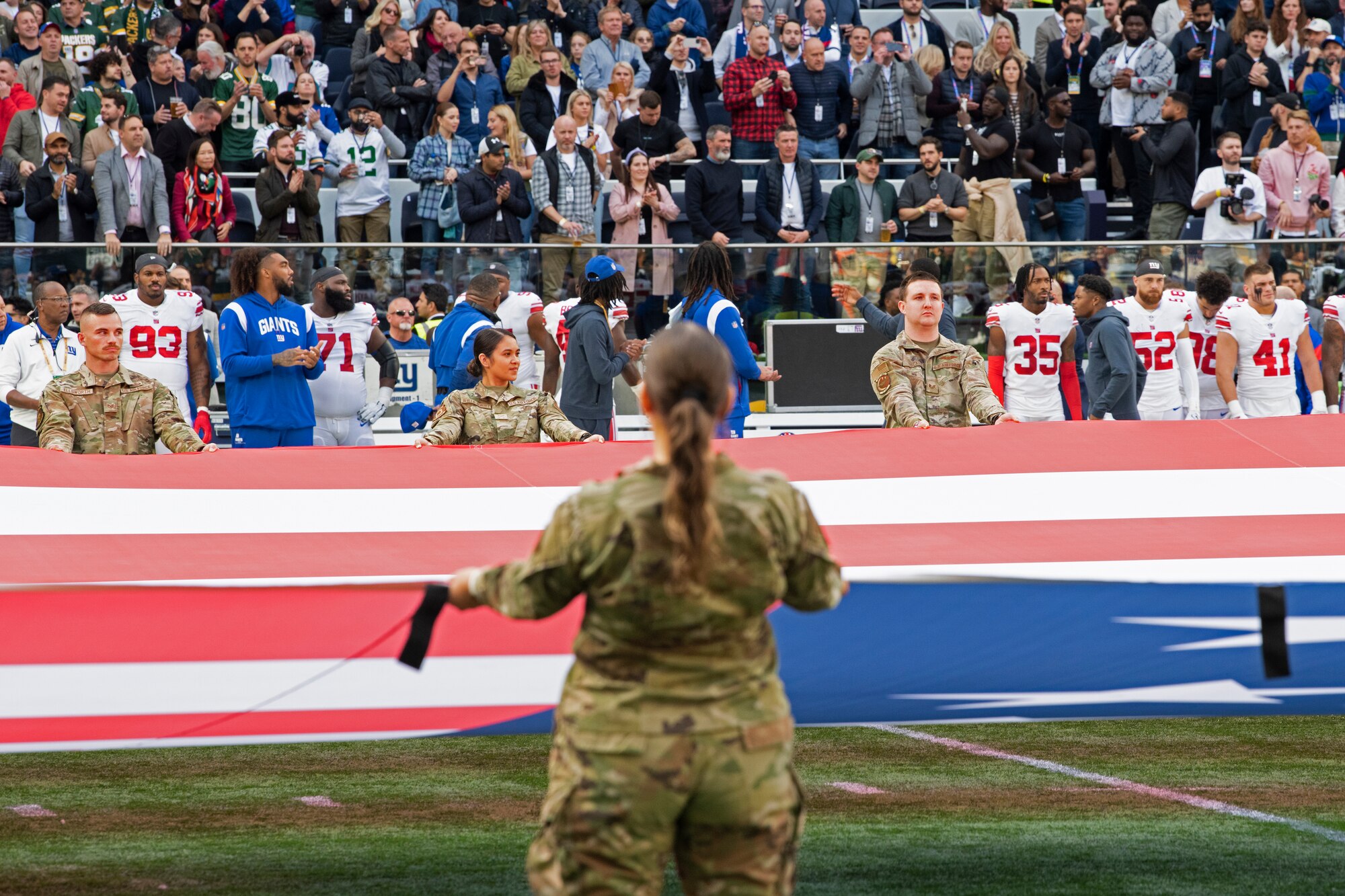 U.S. Airmen assigned to Royal Air Force Mildenhall and RAF Lakenheath hold an unfurled U.S. Flag during the pre-game ceremony of the National Football League’s New York Giants vs. Green Bay Packers game at Tottenham Hotspur Stadium, in London, England, Oct. 9, 2022. The pre-game ceremony featured more than 50 Airmen unfurling the flag along with an honor guard team and vocalist to sing the U.S. National Anthem. (U.S. Air Force photo by Tech. Sgt. Anthony Hetlage)