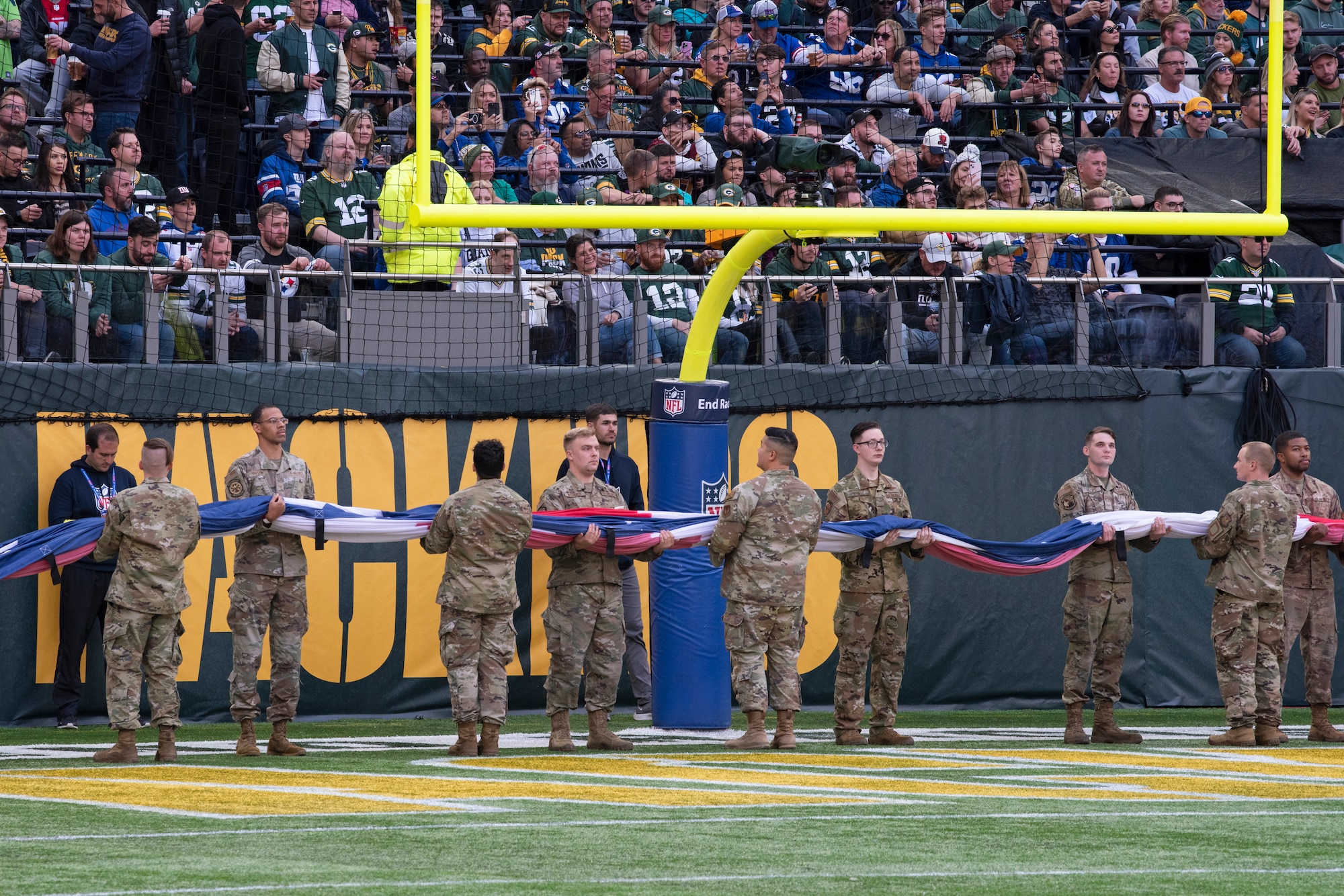 U.S. Airmen assigned to Royal Air Force Mildenhall and RAF Lakenheath prepare to unfurl the U.S. Flag prior to the pre-game ceremony of the National Football League’s New York Giants vs. Green Bay Packers game at Tottenham Hotspur Stadium, in London, England, Oct. 9, 2022. The pre-game ceremony featured more than 50 Airmen unfurling the flag along with an honor guard team and vocalist to sing the U.S. National Anthem. (U.S. Air Force photo by Tech. Sgt. Anthony Hetlage)