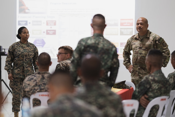 U.S. Air Force Airman and United States Marine Corps Marine teach in front of a classroom