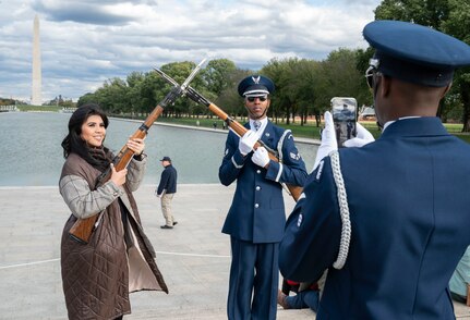 Senior Airman Christian Porter of The United States Air Force Honor Guard Drill Team takes a photo of Honor Guardsman Senior Airman Phillip Reyes and his wife, Roselle Reyes, at the Joint Services Drill Exhibition Oct. 19, 2022, at the Lincoln Memorial Plaza, Washington, D.C. This was the first Joint Services Drill Exhibition in ten years. (U.S. Air Force photo by Jason Trefffry)