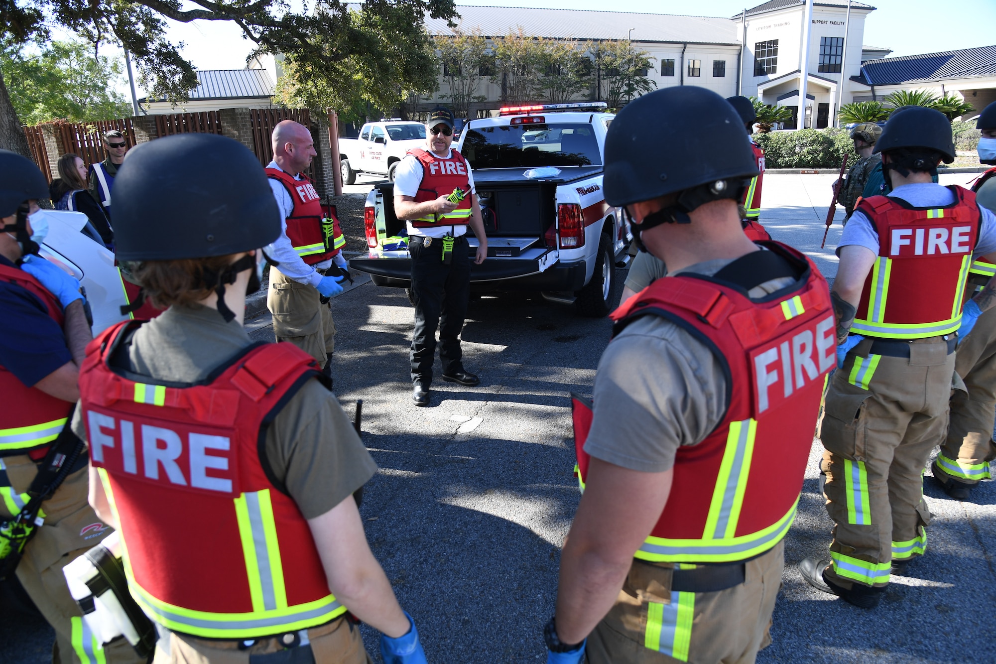 Keesler firefighters gather for an incident review during an active shooter exercise outside the Levitow Training Support Facility at Keesler Air Force Base, Mississippi, Oct. 20, 2022.