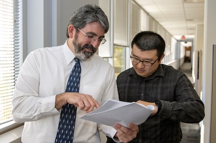 Richard Baughman and Jiho Lee, U.S. Army Financial Management Command Audit Response Center accountants, talk about a document at the Maj. Gen. Emmett J. Bean Federal Center in Indianapolis Oct. 19, 2022. Baughman was awarded the 2021 Louis Dellamonica Award for Outstanding U.S. Army Materiel Command Personnel of the Year. (U.S. Army photo by Mark R. W. Orders-Woempner)