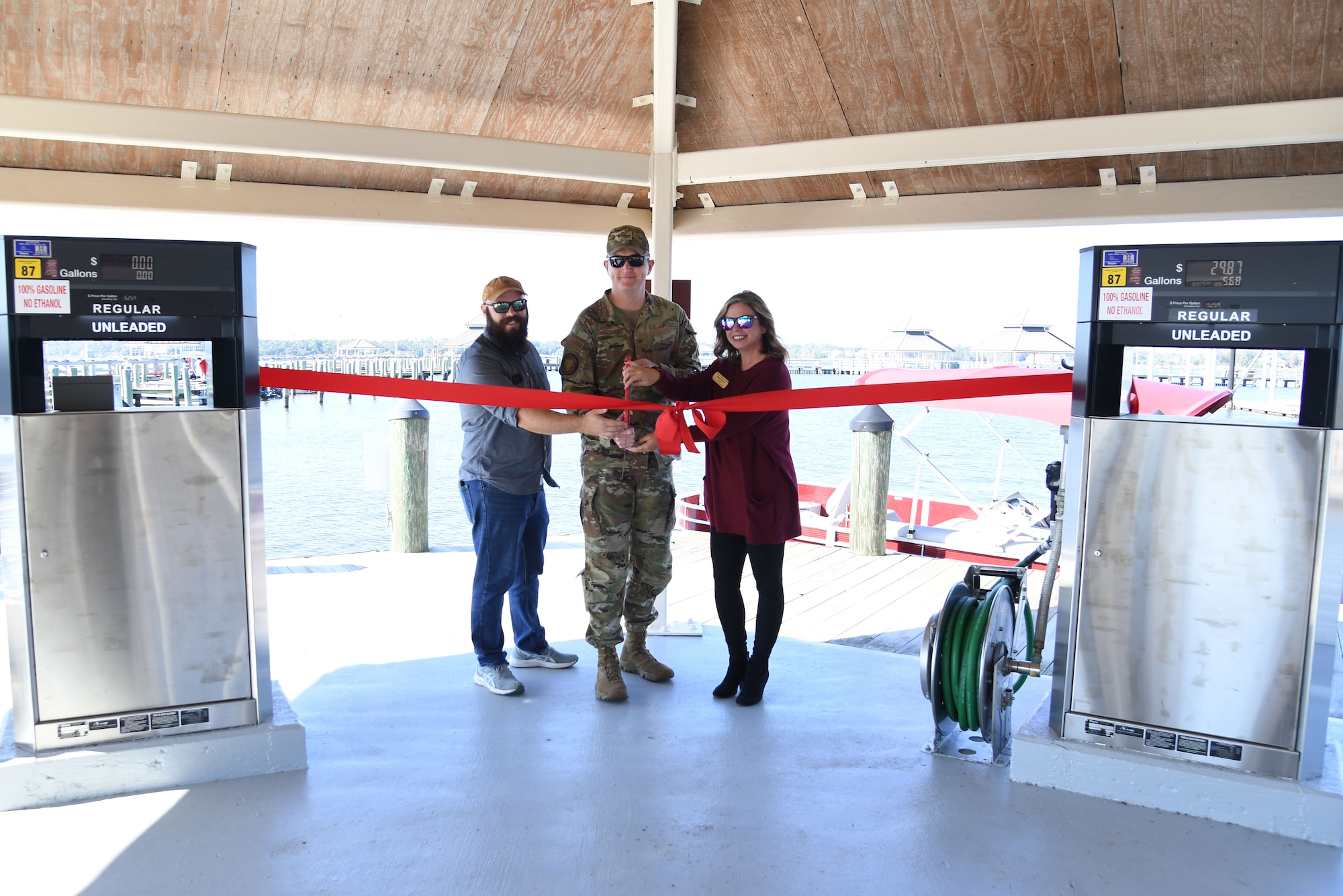 Jacob Craig, 81st Force Support Squadron outdoor recreation deputy director; U.S. Air Force Chad Gemeinhardt, 81st Mission Support Group commander, and Hope Holden, 81st Force Support Squadron community services flight chief, participates in the fuel pier ribbon cutting ceremony at the marina park at Keesler Air Force Base, Mississippi, Oct. 21, 2022.