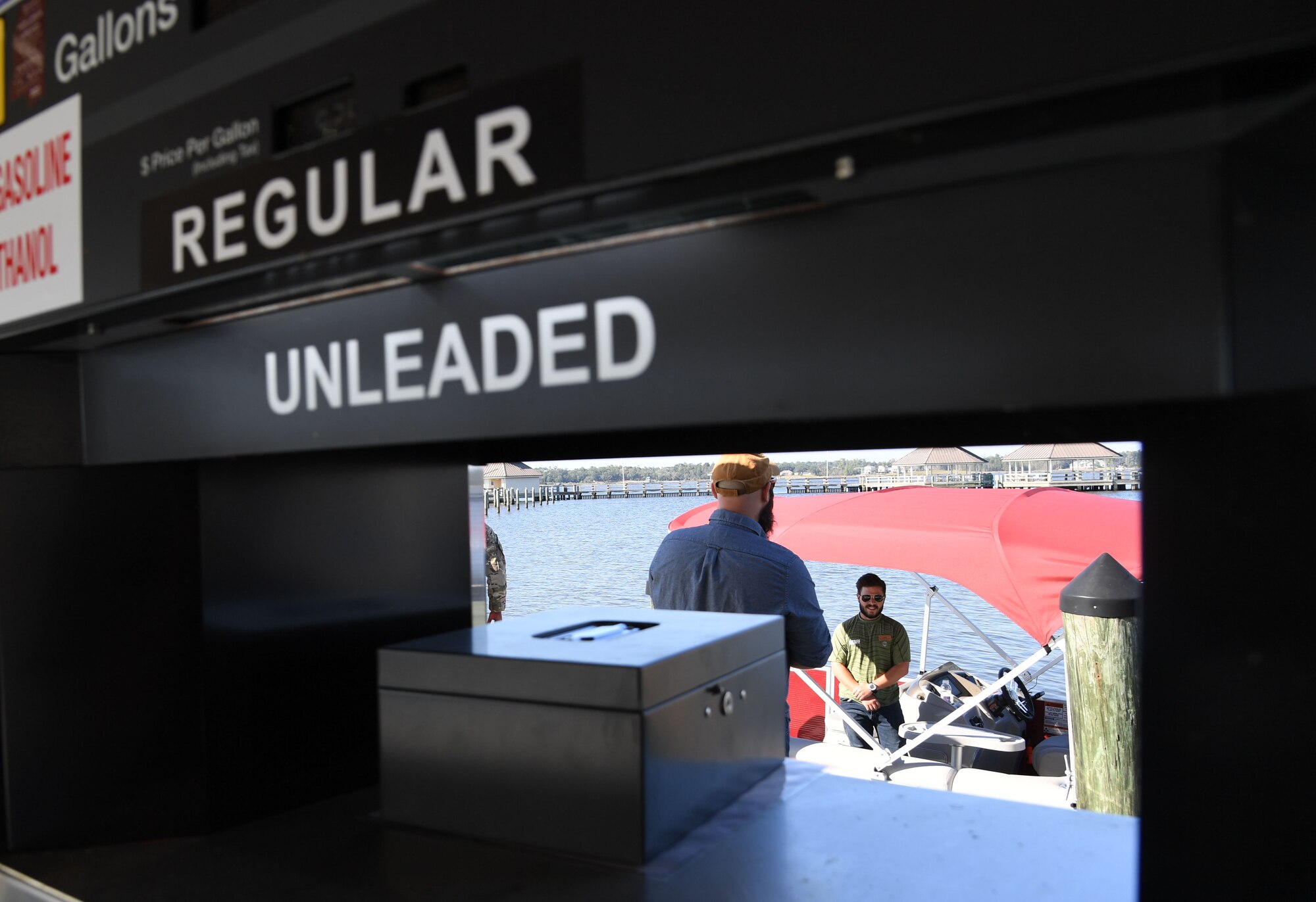 Jacob Craig, 81st Force Support Squadron outdoor recreation deputy director, assists Connor Landwehr, 81st FSS outdoor recreation assistant, with purchasing boating fuel during the fuel pier ribbon cutting ceremony at the marina park at Keesler Air Force Base, Mississippi, Oct. 21, 2022.