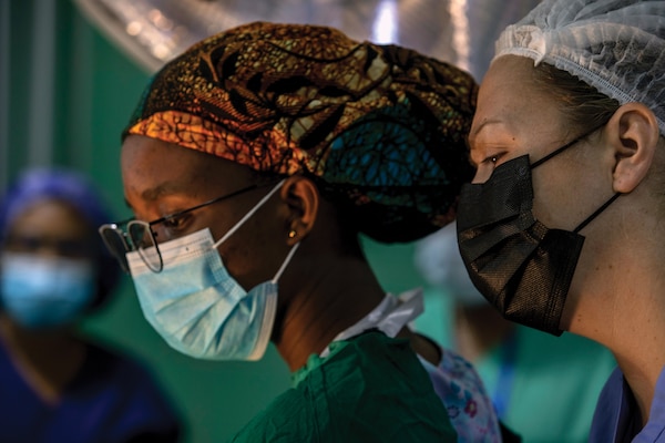 Army Lieutenant Colonel Katherine Hetz (right), general surgeon, with Charlie Company, Brooke Army Medical Center, and Ghanaian army nurse assess patient during surgical procedure at 37th Military Hospital, in Accra, Ghana, June 14, 2022, as part of medical readiness exercise during African Lion 22 (U.S. Army/Ethan Ford)