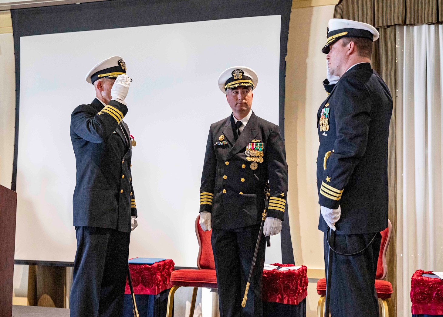 Capt. Brian Hogan, commodore, Submarine Squadron Eight, center, watches as Cmdr. Christopher Holland, right, relieves Cmdr. Jonathan Cantor, left, as commanding officer of the Los Angeles-class attack submarine USS Boise (SSN 764) during a change of command ceremony onboard Naval Station Norfolk, Oct. 21, 2022.