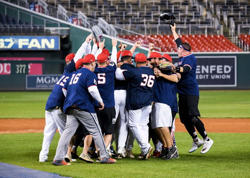 The Joint Base Andrews softball team celebrates their victory after the final out of the Battle of the Bases Championship at Nationals Park in Washington D.C., Oct. 24, 2022.