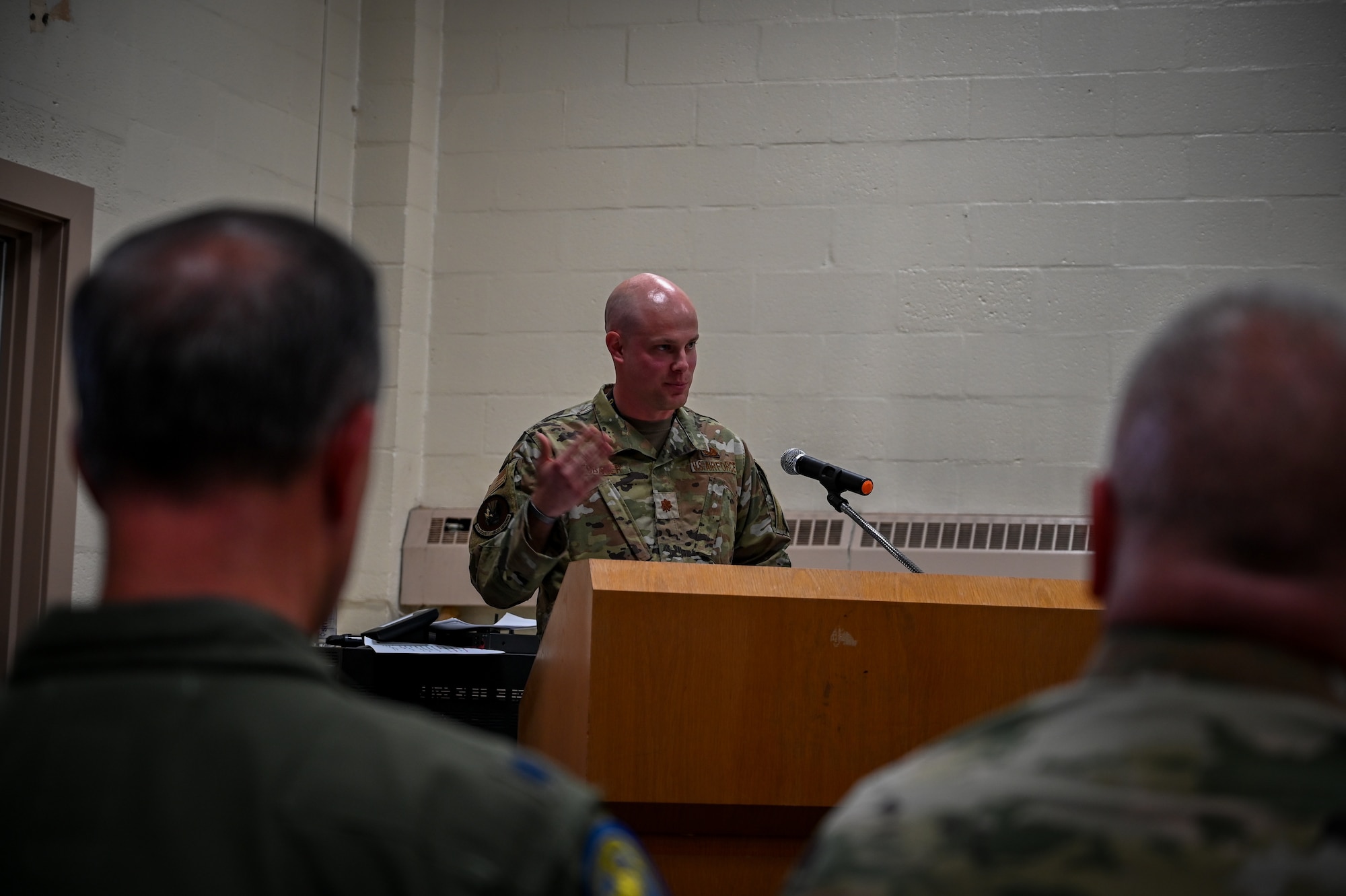 A man in Air Force Uniform speaks at a podium.