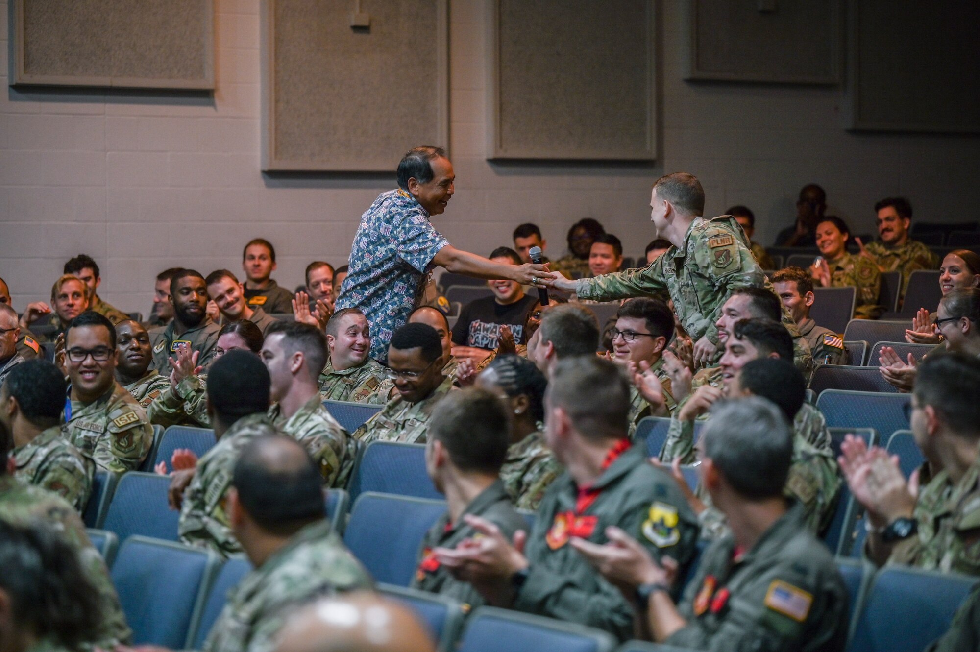 U.S. Navy Rear Admiral (Ret.) Peter Gumataotao, Daniel K. Inouye Asia-Pacific Center for Security Studies director, quizzes Joint Base Pearl Harbor-Hickam Airmen on their knowledge of the Indo-Pacific Region during a Professional Development event hosted by the 15th Operations Group at the Hickam Theater on JBPHH, Hawaii, Oct. 21, 2022. Four attendees were presented with coins after answering several Indo-Pacific theater Geopolitical Megatrends and Regional Pressure Point questions that Gumataotao asked. (U.S. Air Force photo by Staff Sgt. Alan Ricker)