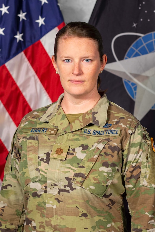 A woman in a camouflage uniform poses for a military portrait.