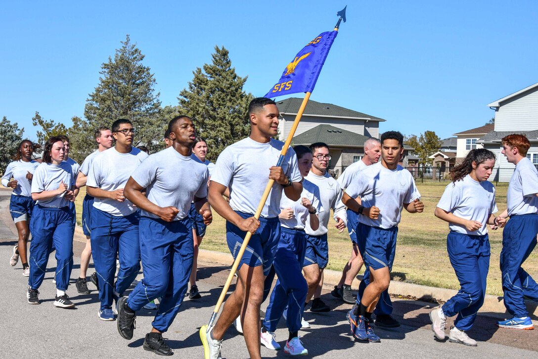 Members from the 97th Security Forces Squadron are joined by Airmen from other squadrons across the 97th Air Mobility Wing as they run 4.5 miles throughout Altus Air Force Base, Oklahoma, Oct. 20, 2022. Day two of the standard is meant to stretch the Airmen physically and test their endurance as they stay together in a formation run. (U.S. Air Force photo by Airman 1st Class Kari Degraffenreed)