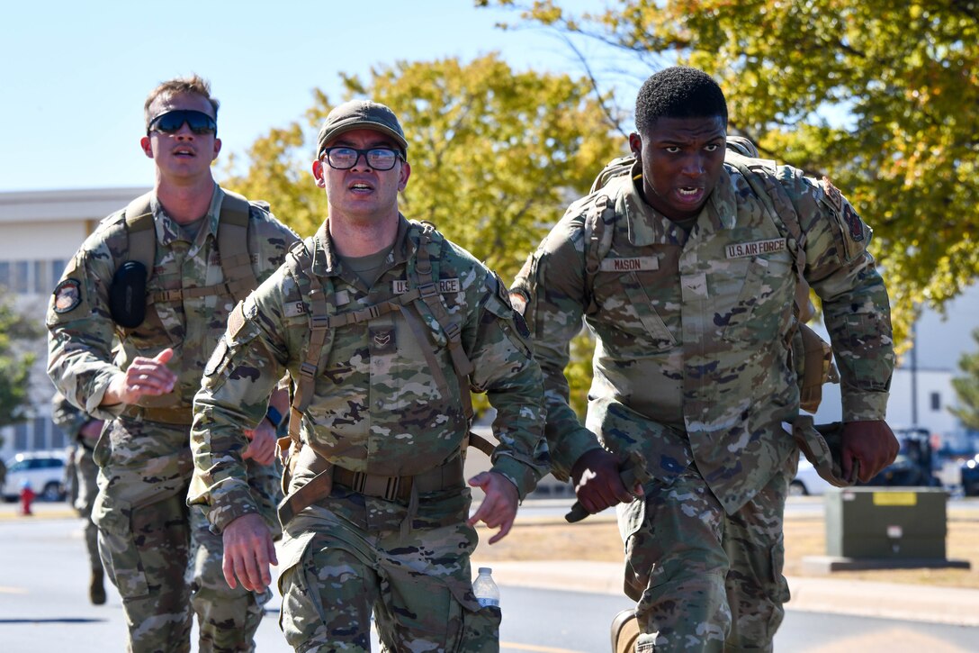 Members from the 97th Security Forces Squadron push themselves to finish their ruck at Altus Air Force Base, Oklahoma, Oct. 22, 2022. During the ruck, teammates helped each other by taking on others rucksacks, trading the ammo cans around, and motivating their wingmen to finish strong and meet the standard. (U.S. Air Force photo by Airman 1st Class Kari Degraffenreed)