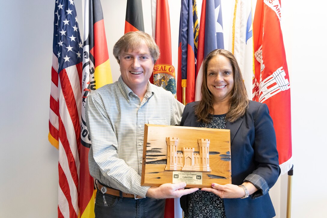 U.S. Army Col. James Booth, Jacksonville District commander, presents Cynthia B. Perez with the Department of the Army Certificate of Retirement for more than 32 years of outstanding and faithful service to the nation.  The citation cited that her accomplishments are indicative of her humility, integrity, and hard work in representing the very best of civil service.  (USACE photo by David Kimery)