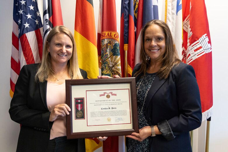 U.S. Army Col. James Booth, Jacksonville District commander, presents Cynthia B. Perez with the Department of the Army Certificate of Retirement for more than 32 years of outstanding and faithful service to the nation.  The citation cited that her accomplishments are indicative of her humility, integrity, and hard work in representing the very best of civil service.  (USACE photo by David Kimery)