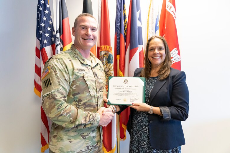 U.S. Army Col. James Booth, Jacksonville District commander, presents Cynthia B. Perez with the Department of the Army Certificate of Retirement for more than 32 years of outstanding and faithful service to the nation.  The citation cited that her accomplishments are indicative of her humility, integrity, and hard work in representing the very best of civil service.  (USACE photo by David Kimery)