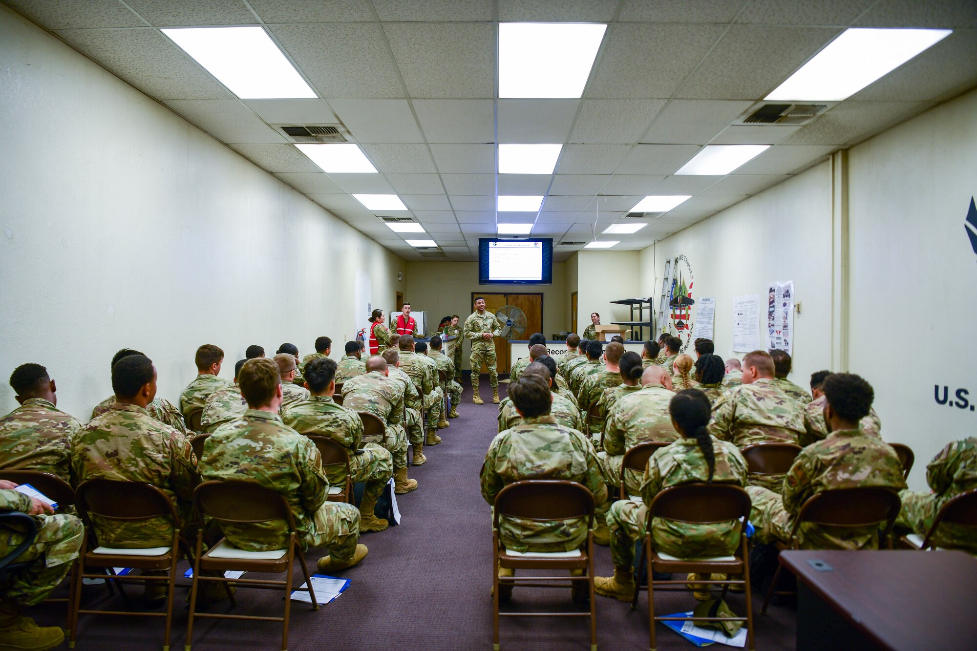 Airmen receive a simulated deployment briefing  during an exercise