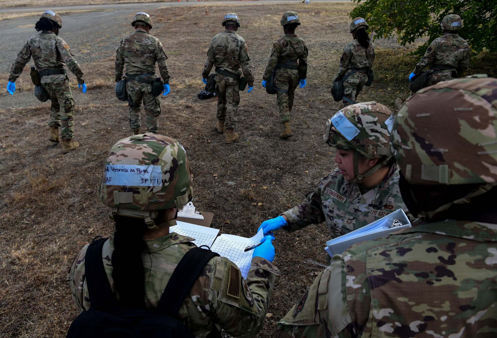 Airmen from the 9th Force Support Squadron work together to walk an area for recovered Airmen