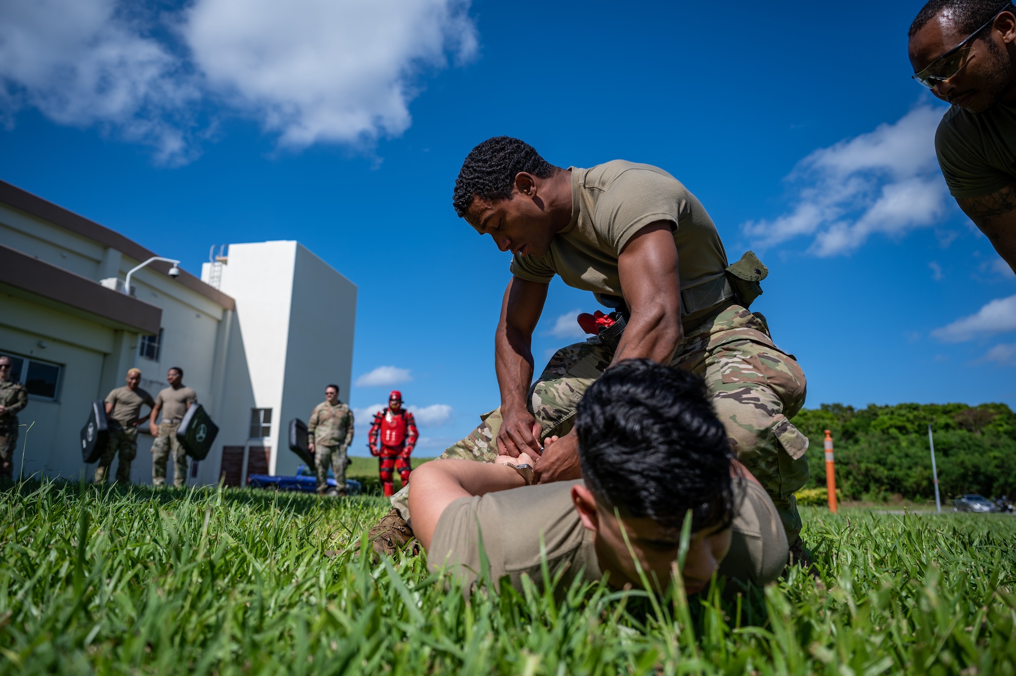 Airman places handcuffs on another Airman.