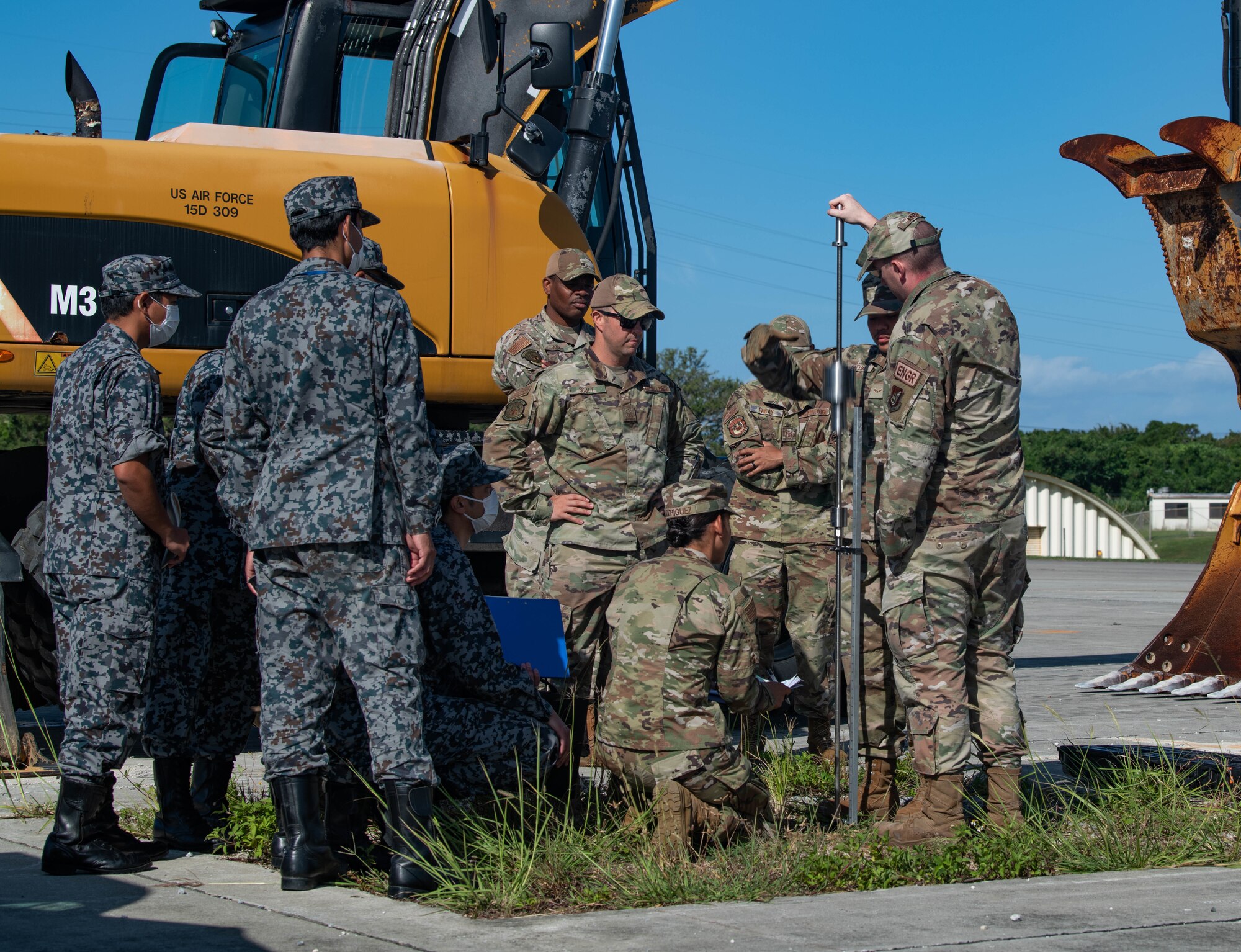 Airmen and Japan Air Self-Defense Force members measure ground compaction.