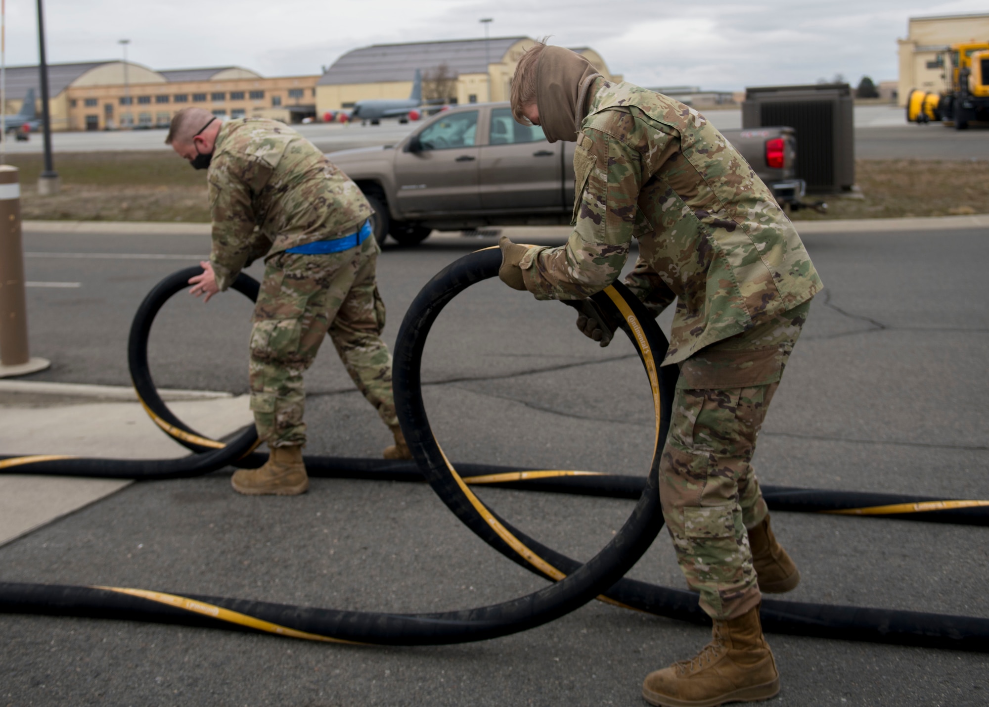 U.S. Air Force Airman 1st Class Spencer Miklos and Airman 1st Class Zachary Burns, 92nd Logistics Readiness Squadron fuels distribution operators, inspect hoses used to refuel aircraft prior to a fueling operation at Fairchild Air Force Base, Washington, March 15, 2021. The 92nd LRS fuels management flight’s mission is to verify the quality of all fuel that comes in and out of the base to ensure the 92nd Air Refueling Wing is always mission ready. (U.S. Air Force photo by Senior Airman Lawrence Sena)