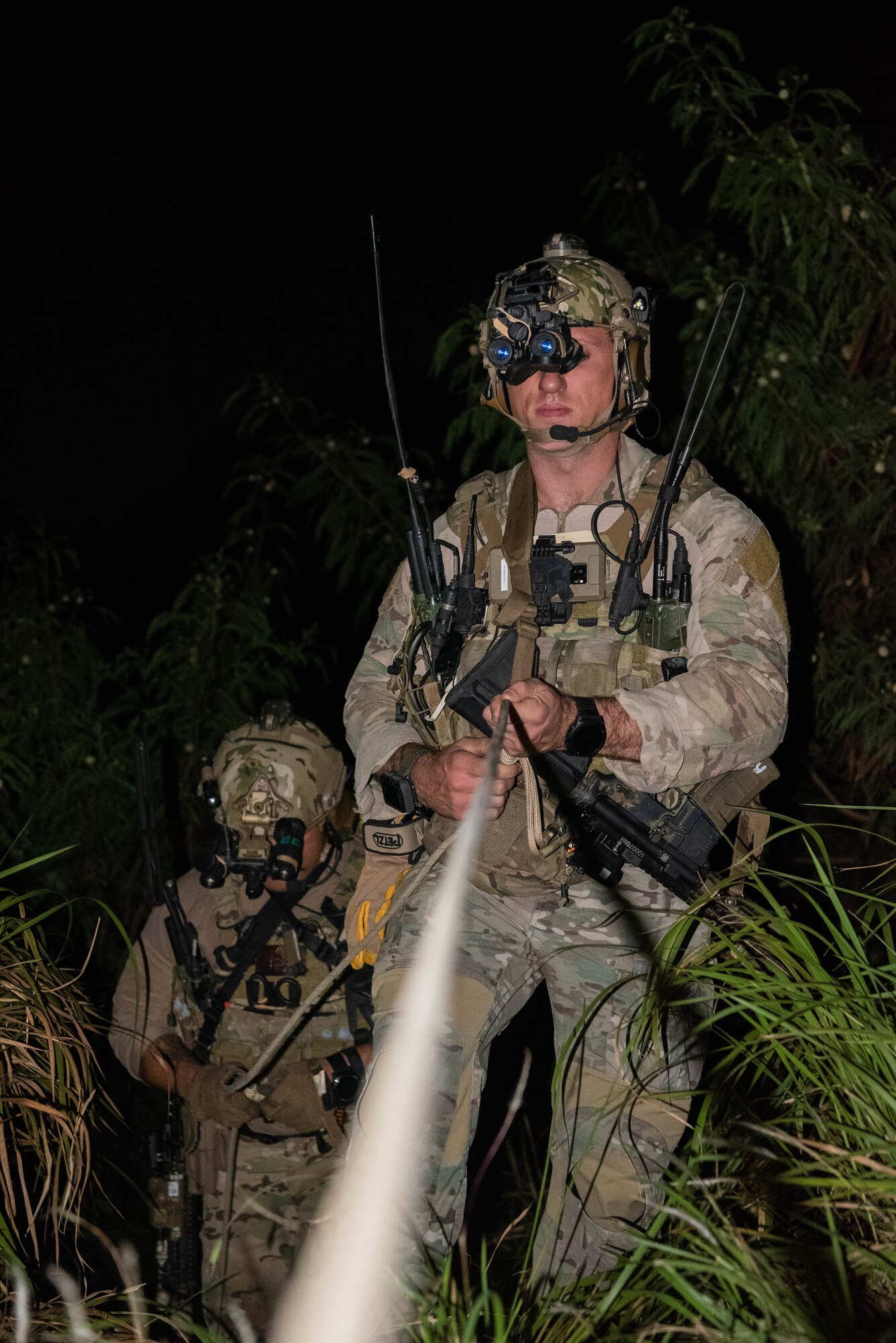 Airmen descend a slope.