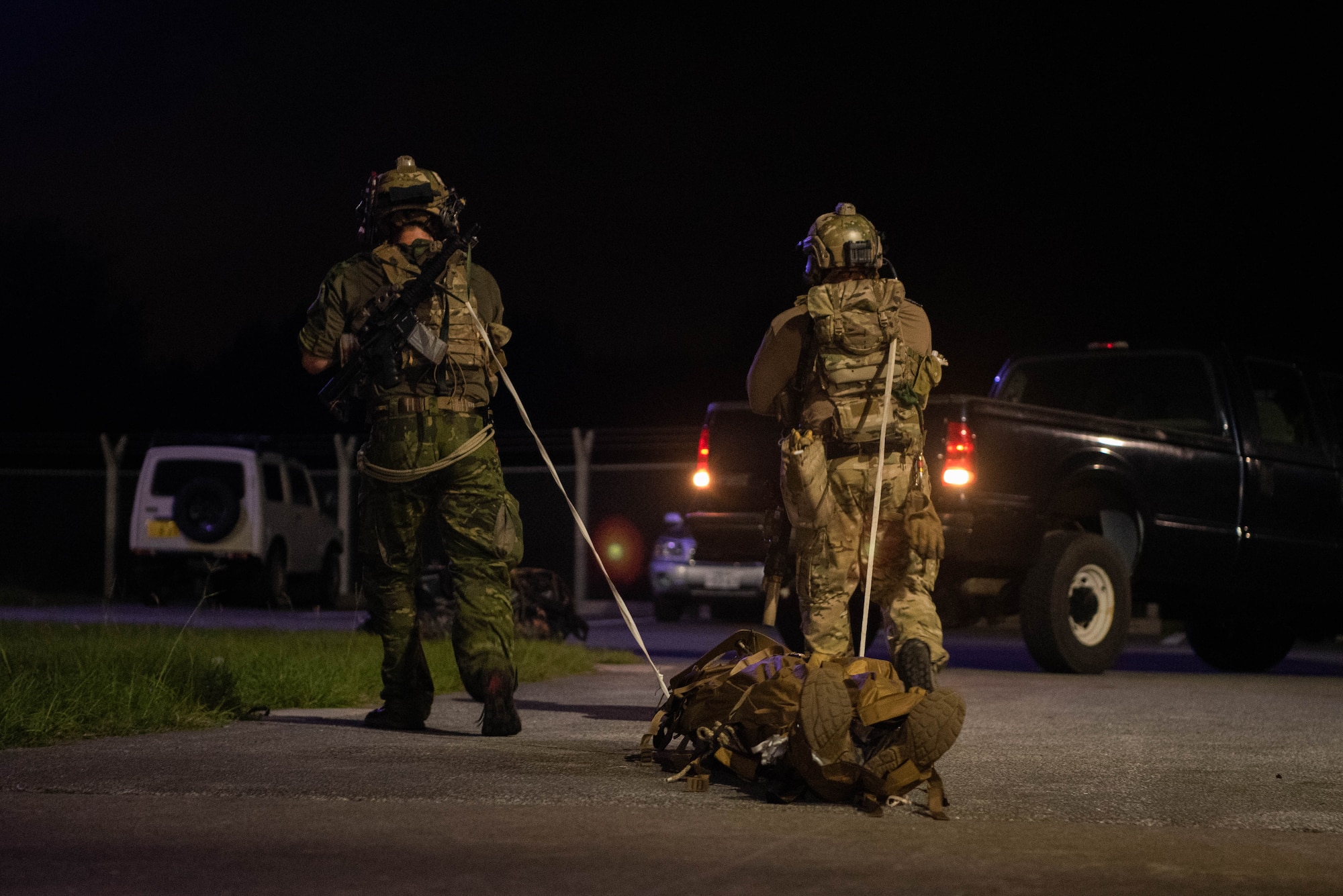 Airmen drag a litter holding a patient.