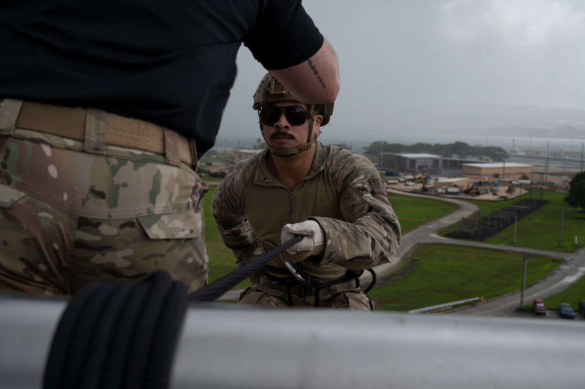 U.S. Air Force Senior Airman Jean Novenario, 736th Security Forces Squadron Airman, prepares to rappel down a U.S. Navy Explosive Ordinance Disposal Tower on Naval Base, Guam, Oct. 21, 2022. The 736 SFS, 554th Rapid Engineer Deployable Heavy Operational Repair Squadron Engineers and 36th Contingency Response Squadron partook in a training exercise that aimed toward updating and refreshing their skills in rappelling. (U.S. Air Force photo by Airman 1st Class Lauren Clevenger)