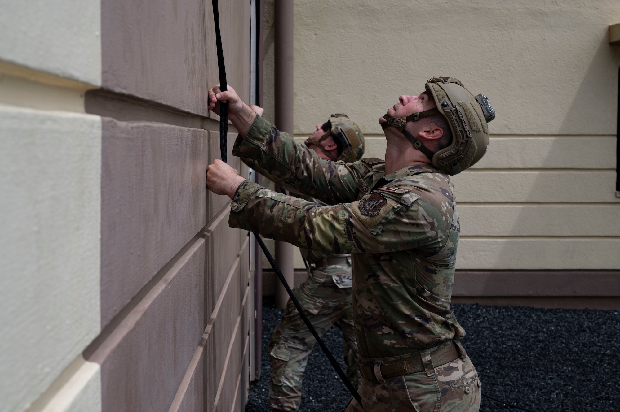 U.S. Air Force Airmen assigned to 736th Security Forces Squadron hold ropes while Airmen rappel down a U.S. Navy Explosive Ordinance Disposal Tower on Naval Base, Guam, Oct. 21, 2022. The 736 SFS, 554th Rapid Engineer Deployable Heavy Operational Repair Squadron Engineers and 36th Contingency Response Squadron partook in a training exercise that aimed toward updating and refreshing their skills in rappelling. (U.S. Air Force photo by Airman 1st Class Lauren Clevenger)