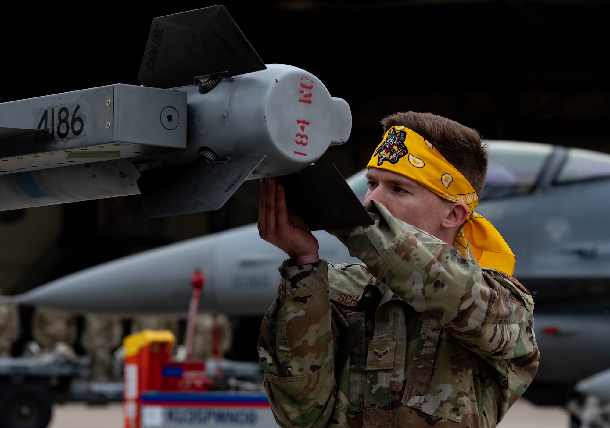 80th Fighter Generation Squadron weapons load crew member attaches the wings of an AIM-9 missile