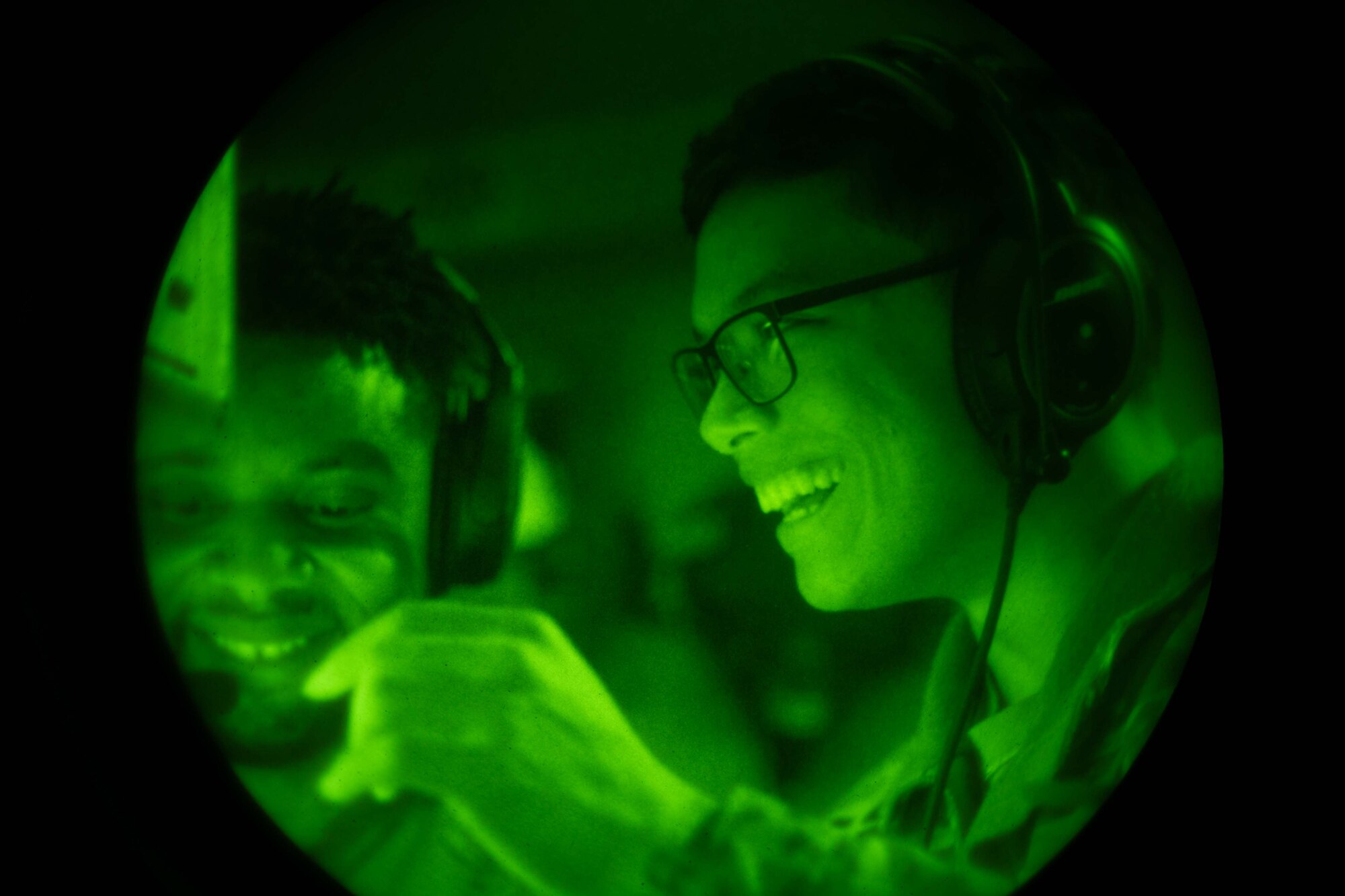 From the right, Senior Airman Frankie Arceo, speaks with Tech. Sgt. Tayonn Harvey, both 3rd Airlift Squadron loadmasters, during a training flight aboard a C-17 Globemaster III over Delaware, Oct. 24, 2022. Airmen from the 3rd AS routinely fly training missions on C-17s to rehearse global support. (U.S. Air Force photo by Senior Airman Faith Barron)