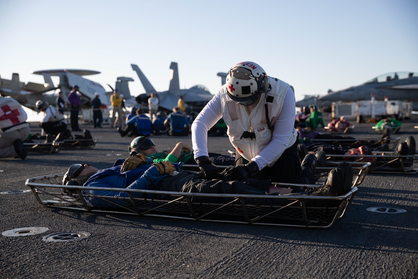 Hospital Corpsman 2nd Class Daniel Nerino, from Virginia Beach, Virginia, assigned to the "Tomcatters" of Strike Fighter Squadron (VFA) 31, applies a tourniquet to a simulated victim during a simulated mass casualty drill on the flight deck, Oct. 14, 2022. The Gerald R. Ford Carrier Strike Group (GRFCSG) is deployed in the Atlantic Ocean, conducting training and operations alongside NATO Allies and partners to enhance integration for future operations and demonstrate the U.S. Navy’s commitment to a peaceful, stable and conflict-free Atlantic region. (U.S. Navy photo by Mass Communication Specialist 2nd Class Jackson Adkins)