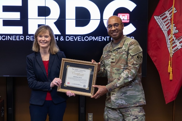 U.S. Army Engineer Research and Development Center (ERDC) Deputy Director Dr. Beth Fleming and ERDC Commander Col. Christian Patterson pose with a diploma as they offer their congratulations to Matthew Glover, a geophysicist with the U.S. Army Corps of Engineers St. Louis District, who presented his research results virtually at the ERDC University graduation ceremony Sept. 15, 2022. (U.S. Army Corps of Engineers photo by Oscar Reihsmann)