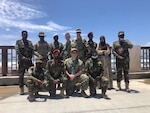 Lt. Josh Root, Lt. Cmdr. Colin Hood, and U.S. Army Capt. Sean O’Dowd pose for a graduation photo with Somali National Army forces at the conclusion of legal training in support of the transfer of military aid.