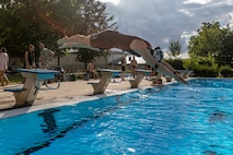 A woman dives into a pool.